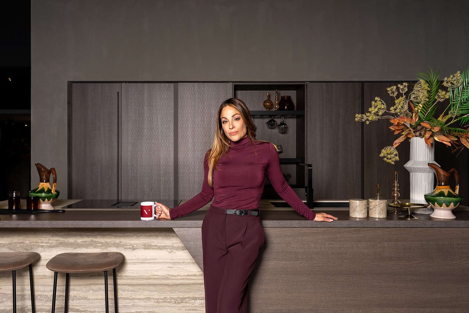 Ira Losco standing at a dark contemporary kitchen island with concealed storage