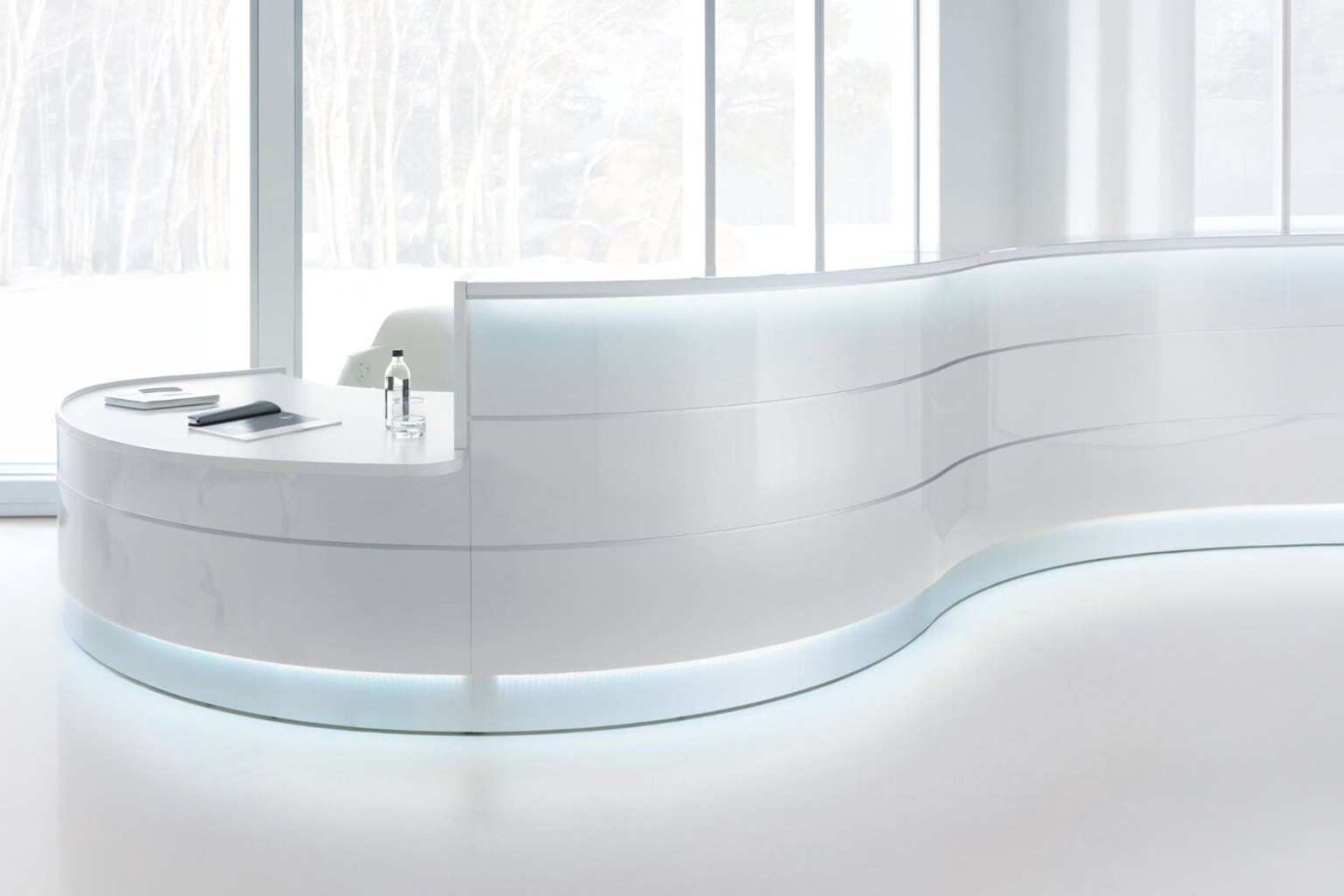 Curved white reception desk in a bright modern entrance