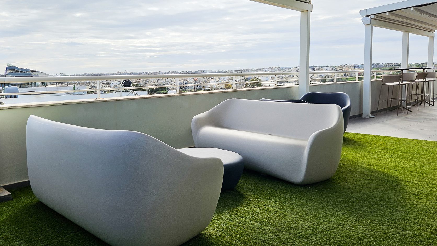 Outdoor terrace at Alter Domus furnished with lounge seating and city views